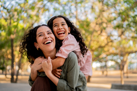 happy mother and daughter playing in the park