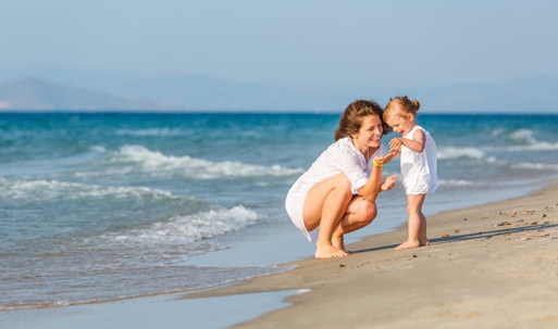 Mother with little daughter on the beach